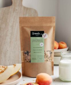 w opakowaniu na stole granola z pistacjami, syropem klonowym, płatkami migdałowymi i kokosowymi