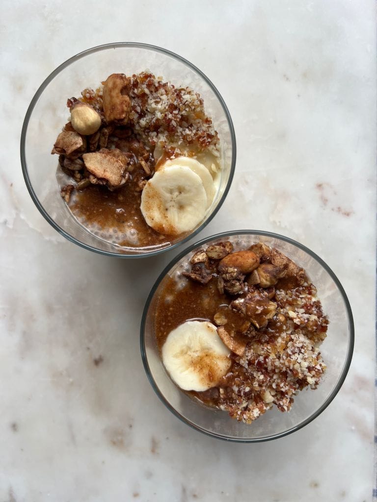 Banoffee Chia Pudding z kruszonką z daktyli i migdałów w szklankach na blacie stołu