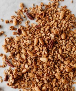 Widoczne orzechy pekan i migdały blanszowane oraz płatki owsiane opiekane w kajmaku.