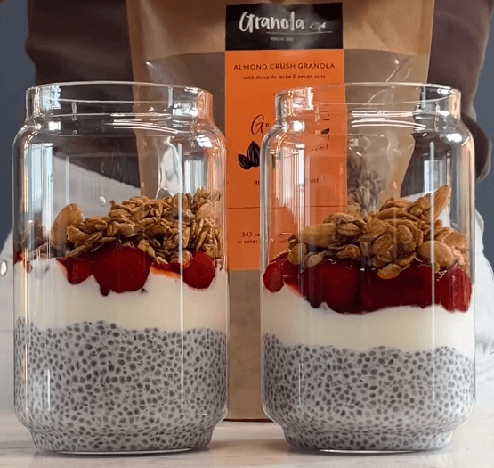 Dwa słoiki zawierające danie chia pudding z truskawkami w żelu